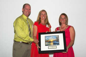 Chris and Sloan Freeman accept the award from federation' education coordinator, Sarah Phillips, right.