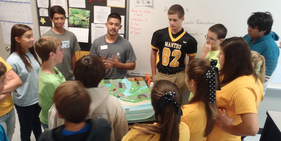 Education intern Daniel Salazar, leads a student session at Manteo Middle School using the stormwater model demonstration.
