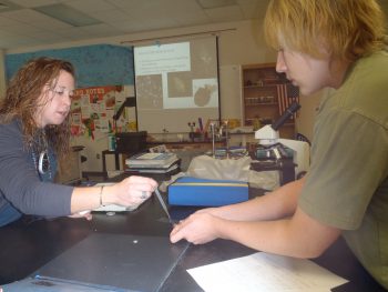 Educator Sara Hallas guides a student during an oyster lab.