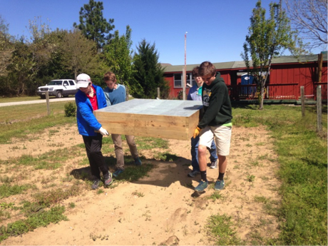 Boy Scouts help install raised beds they built as demonstration gardens