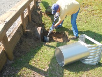 Dr. Charlie Humphrey installs a water control structure into a culvert