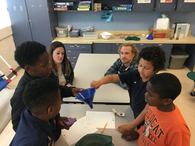 Students use a funnel and coffee filter for a lesson on oysters.