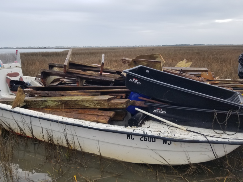 An old boat on the banks of the marsh filled with debris which was also removed from the area.