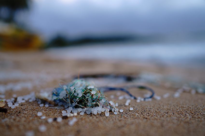 Bead-like microplastics on the sand of a beach.