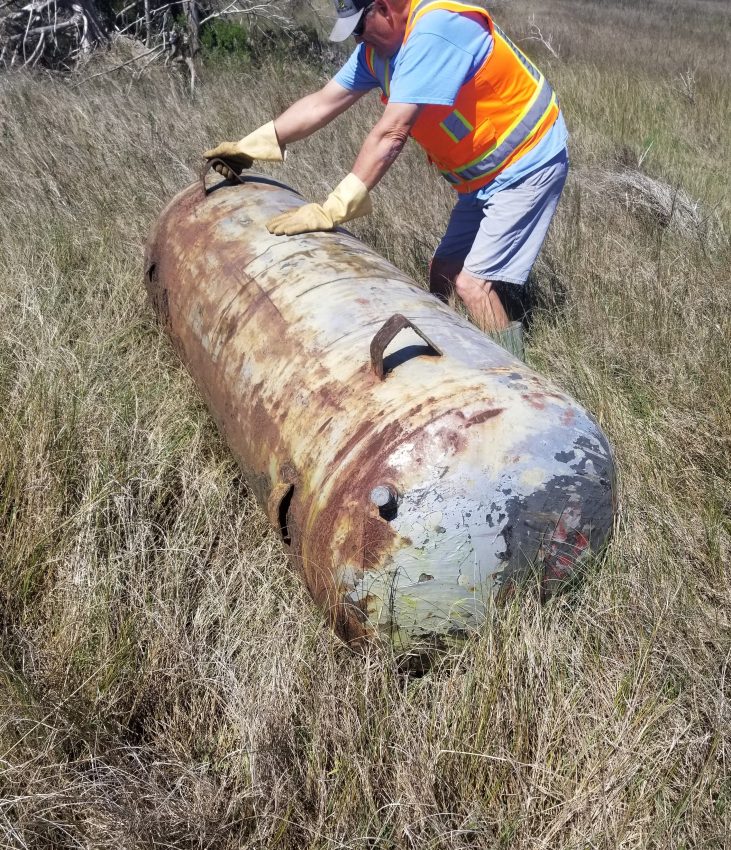 Oil Drum being removed by a member of the Marine Debris Collection Crew