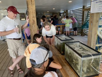 An intern helps explain what's in two fish tanks