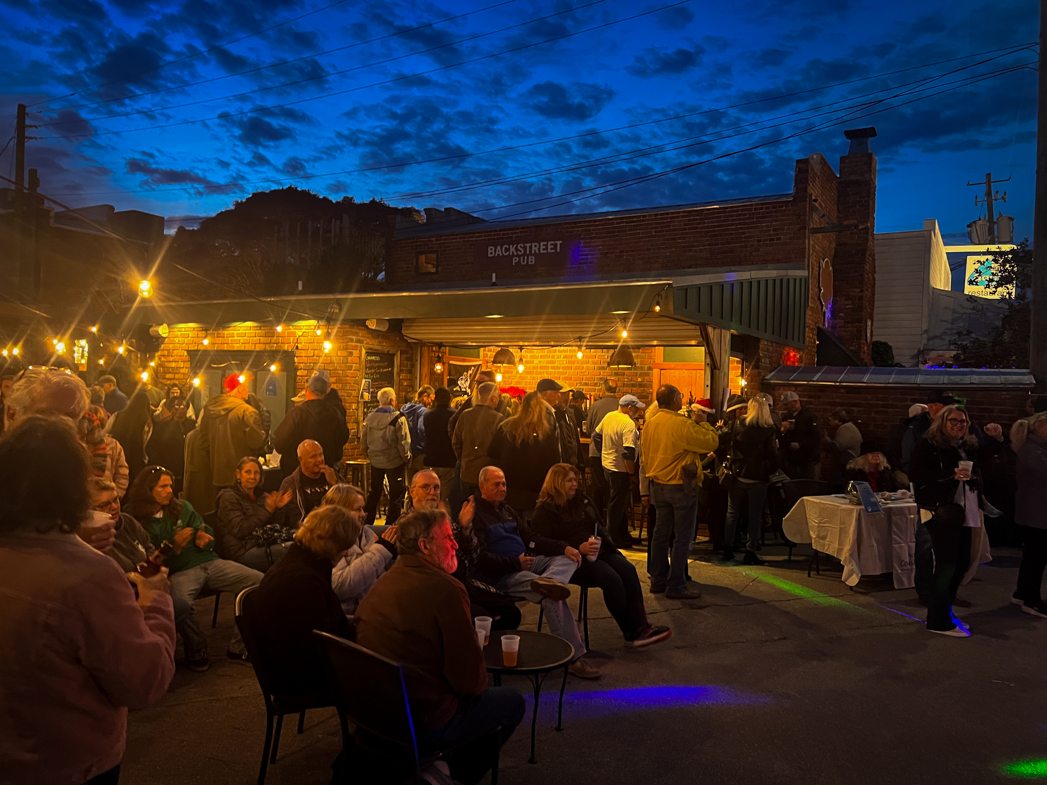 A group of people enjoy listening to music at the 2023 NC Fest at Backstreet Pub in Beaufort.